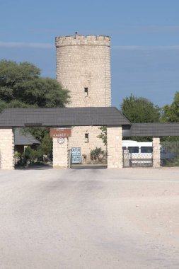 Mavi gökyüzü olan bir tarlanın ortasındaki ahşap evin dikey görüntüsü.