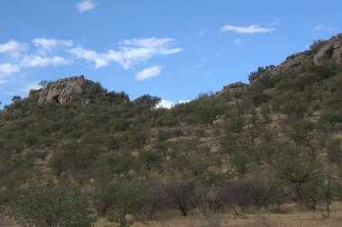 Dağları ve mavi gökyüzü olan güzel bir manzara.