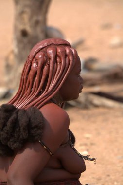 Himba kabilesinin köyündeki genç kadın.