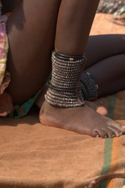 Geleneksel kıyafetlerle oturan kadın.