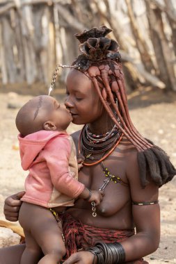 Çölde çocuklu genç bir kadın.