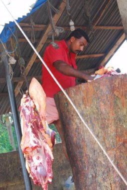 Adam barbeküde et kesiyor.