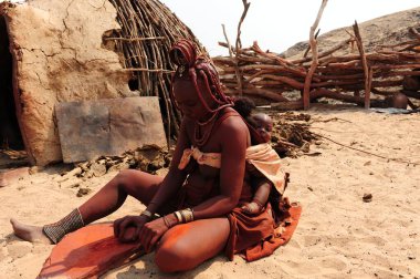 Çölde çantalı geleneksel elbiseli bir kadın.