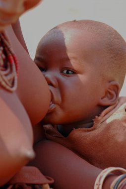 Genç anne bebeğini çocuğuyla besliyor.