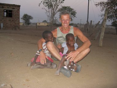 Çölde köpeği olan Afrikalı bir adam.