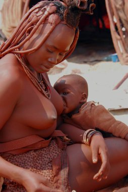 Himba kabilesinde çocuklu genç bir anne.