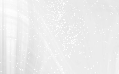 Yumuşak beyaz dokuları olan soyut bir arkaplan ve dağınık ışık parçacıkları sakin bir ortam yaratıyor