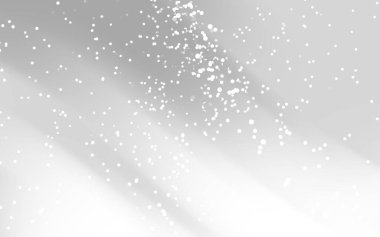 Yumuşak beyaz parçacıklar bulanık gri bir arkaplana hafifçe çarpıyor ve sakin bir atmosfer yaratıyor.