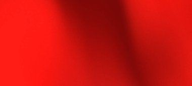 Canlı kırmızı kumaş zarif bir şekilde örtülmüş, arka planda yumuşak gölgeler olan pürüzsüz bir doku oluşturmuş.