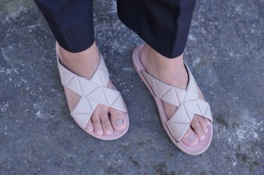 Bir kadın tarafından giyilen pembe renkli sandaletler.