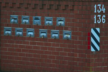  Tuğla çit, güvenlik için asma kilitli özel posta kutularını barındırıyor. 22 07 2025                             