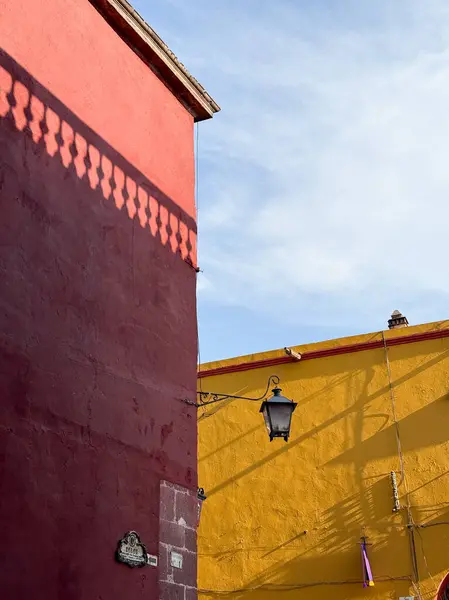 San Miguel de Allende, Meksika 'daki renkli koloni döneminden kalma bina duvarları. Kırmızı ve sarı renkte. Güneş ışığıyla aydınlatılıyor..