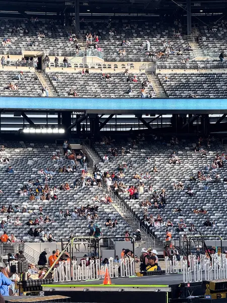 İzleyiciler gün ışığında açık hava tribünlerinde bir spor müsabakasına hazırlanmak için toplandılar..