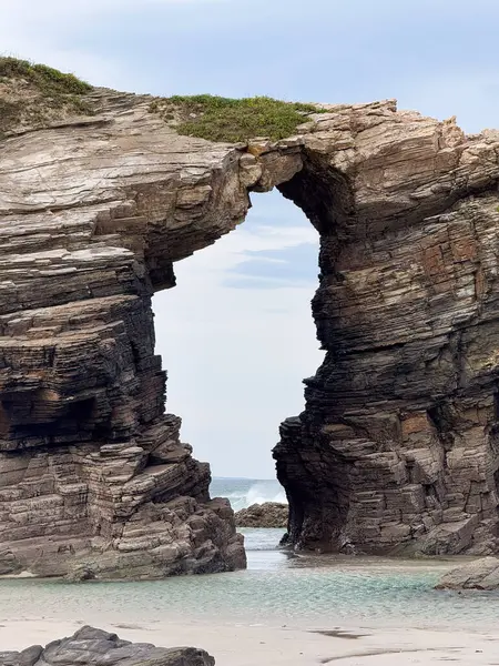 Galiçya, İspanya 'daki Playa de las Katedralleri' ndeki büyük doğal taş kemer dalgaların ve el değmemiş beyaz kumların üzerinde duruyor..