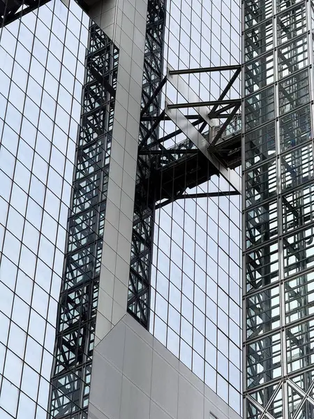 Osaka 'da cam yansımalı bir inşaat alanında vinç ve iskele..