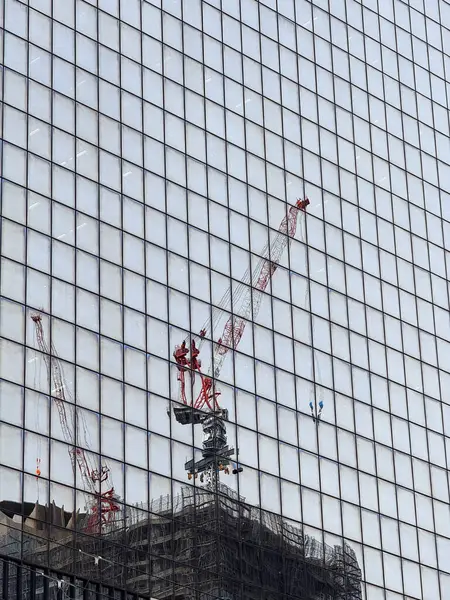 Osaka 'da cam bir binanın yan tarafında bir inşaat vinci görüldü..