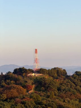 N Seul Kulesi, altın saat boyunca Güney Kore 'deki yeşil dağların üzerinden yükseliyor..
