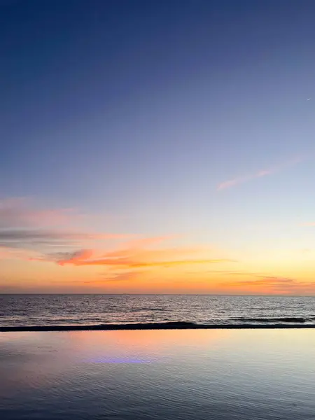 Mavi-turuncu gün batımı, Mazatlan 'daki Pasifik' e bakan sonsuz bir havuza yansıyor..
