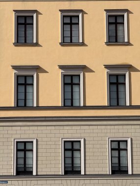 A close-up architectural grid of windows on a beige building facade in Oslo.