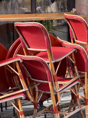 Bright red cafe chairs stacked together on a street in Stockholm.