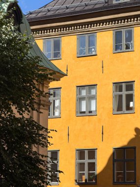 Historic yellow building facade with windows in central Stockholm.