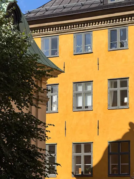 Historic yellow building facade with windows in central Stockholm.