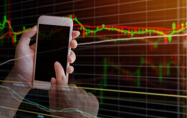 Çift el üzerinde pozlama smartphone ile borsa grafik ekran arka planı üzerinde. kırmızı renk arka plan için forex ve stok kavramı ile filtre.