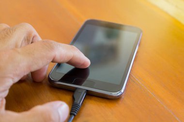 Seçici odak - el dokunma ve hareket eden, cep telefonu, akıllı telefon için arka plan kullanarak ahşap masa veya ahşap zemin. 