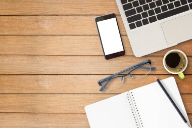 Dizüstü bilgisayar ve ahşap masa üzerinde kahve ile akıllı telefon. Kopya alanı için herhangi bir tasarım ile Üstten Görünüm