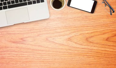 Dizüstü comuter, gözlük, akıllı telefon ve kahve ahşap ofis masasında. kopya alanı ile Üstten Görünüm