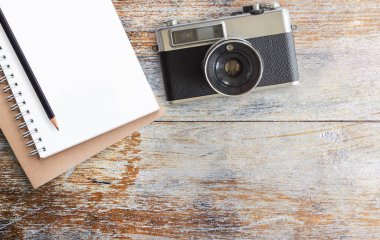 Ofis resepsiyon masası ile vintage fotoğraf makinesi ve ahşap arka plan üstünde not etmek. Kopya alanı ile Üstten Görünüm