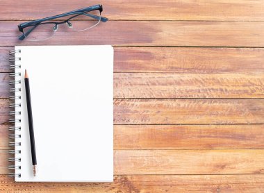 Office ile ahşap masa üst görünümünü sağlar. Ofis resepsiyon masası defter, kalem ve gözlük. kopya alanı tasarımı için