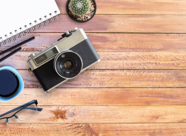 Office ile ahşap masa üst görünümünü sağlar. Ofis resepsiyon masası ile defter, kalem ve vintage fotoğraf makinesi. kopya alanı tasarımı için