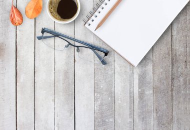 Dizüstü bilgisayarlar ve kahve ofis masa ya da ahşap masaları gözlüklerle. kopya alanı tasarım ile Üstten Görünüm