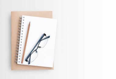 Beyaz arka plan üzerinde boş kağıt defter. Üstten Görünüm kopya alanı (seçici odak) ile. Ofis Resepsiyon Masa kavramı.