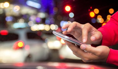 Erkek el gece bokeh arka plan ile akıllı telefon tutarak. Kopya alanı herhangi bir tasarım için