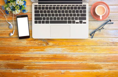 Düz yatıyordu ofis resepsiyon masası fincan kahve, dizüstü bilgisayar, gözlük ve akıllı telefon ile. Kopya alanı ile Üstten Görünüm