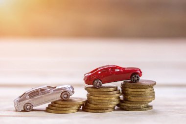 Minyatür oyuncak araba ve para para ahşap masa arka plan güneş ışığı ile. Mali ve para kavramı. Ofis Masası para sikke ve iş finansal planlama ile