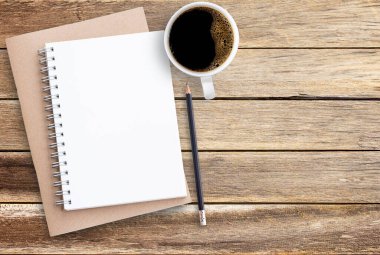 Ahşap masa arka plan üzerinde üstten görünüm defter kalem ve kahve. İş Danışma en az tarzı kavramı kopya alanı için herhangi bir tasarım ile.