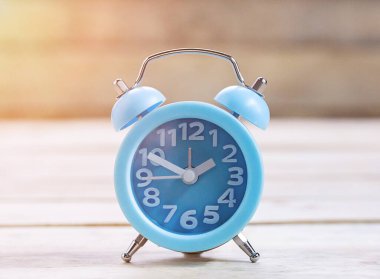 Güneş ışığı, zaman ve eğitim kavramı fikir ahşap masa zemin üzerine Retro vintage çalar saat.