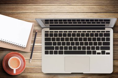 Ofis masası - Laptop bilgisayar, dizüstü bilgisayar ve kahve fincanı kahverengi ahşap dokuda ve arka planda fotokopi alanı var. Herhangi bir tasarım ve kullanım için tahta arkaplan.