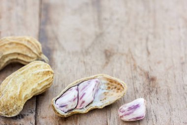 Kavrulmuş veya satır fıstık rustik, koyu ahşap masa arka plan üzerinde dağınık. sağlıklı gıda arka plan ile kopya alanı kullanmak için.