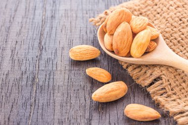 Soyulmuş badem tahta kaşık ahşap zemin üzerine kapatın. Kopya alanı tasarımı için