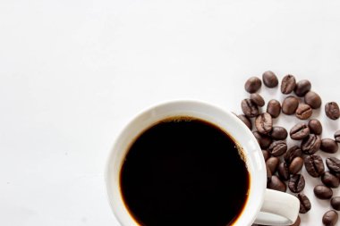 Üstten Görünüm sıcak kahve ve kahve çekirdekleri beyaz arka plan üzerinde. kopya alanı tasarımı için