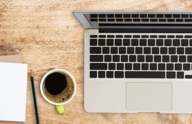 Dizüstü bilgisayarı, kahve fincanı ve kurşun kalemi olan ofis masası..