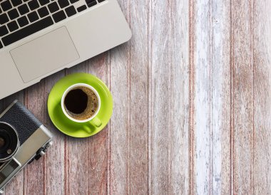 Kahve kupa, dizüstü bilgisayar ve kopya alanı ile ahşap masa üzerinde eski fotoğraf makinesi 