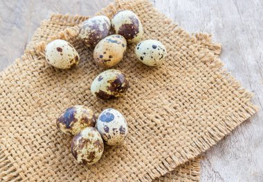 Çuvala bir ahşap masa arka planda bıldırcın yumurtası