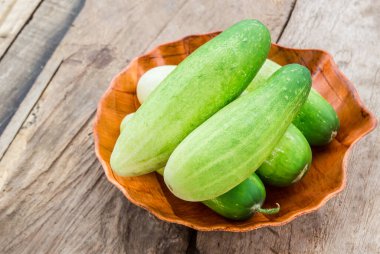 Ahşap masa arka plan üzerinde ahşap plaka taze salatalık