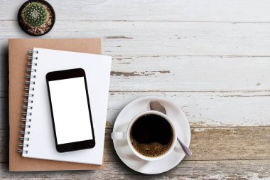 Boş not defteri, akıllı telefon ve kahve fincanı kopya alanı ahşap tablo