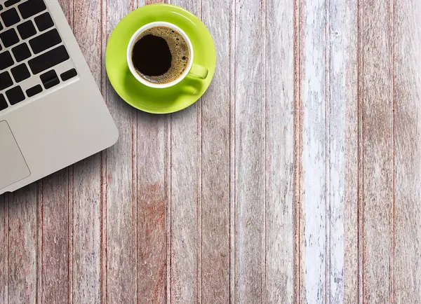 Ofis masaları ile dizüstü bilgisayar ve ahşap masa üzerinde kahve fincanı. Yukarıdan kopya alanı ile göster